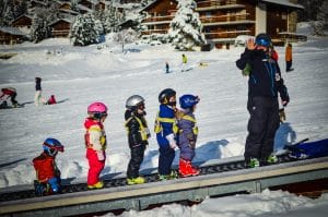 Kate ridding the magic carpet with her Penguins group Children's Skiing