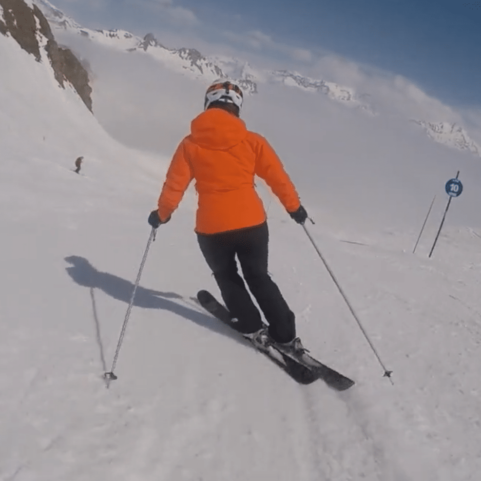 woman in orange top skiiing square
